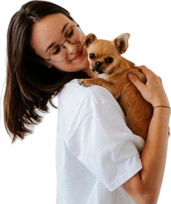 Joven sonriendo mientras abraza a su perrito chihuahua